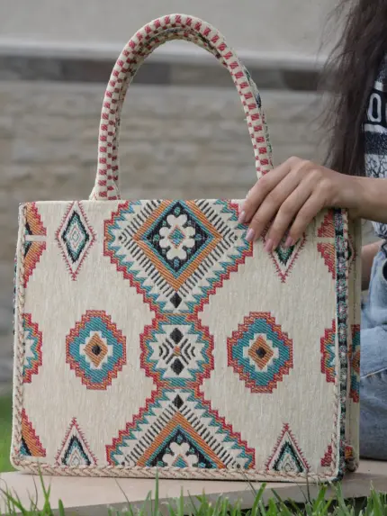 Berber pattern handbag with intricate colorful shapes ,featuring sturdy top handles and a black suede interior