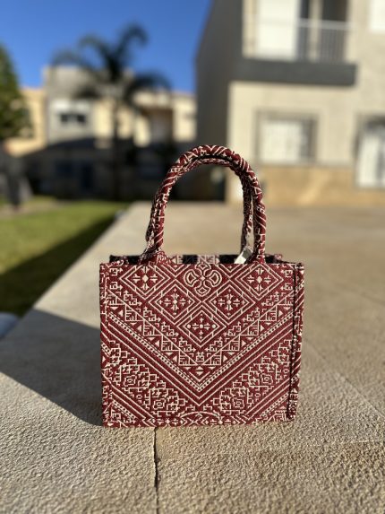 red embroidered handbag with intricate Fassi patterns, featuring sturdy top handles and a black suede interior