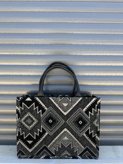 Berber pattern handbag with intricate colorful shapes ,featuring sturdy top handles and a black suede interior