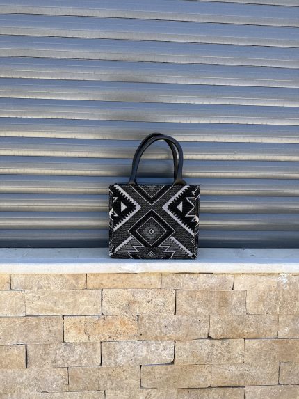 Berber pattern handbag with intricate colorful shapes ,featuring sturdy top handles and a black suede interior