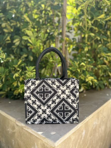 Berber pattern handbag with intricate colorful shapes ,featuring sturdy top handles and a black suede interior